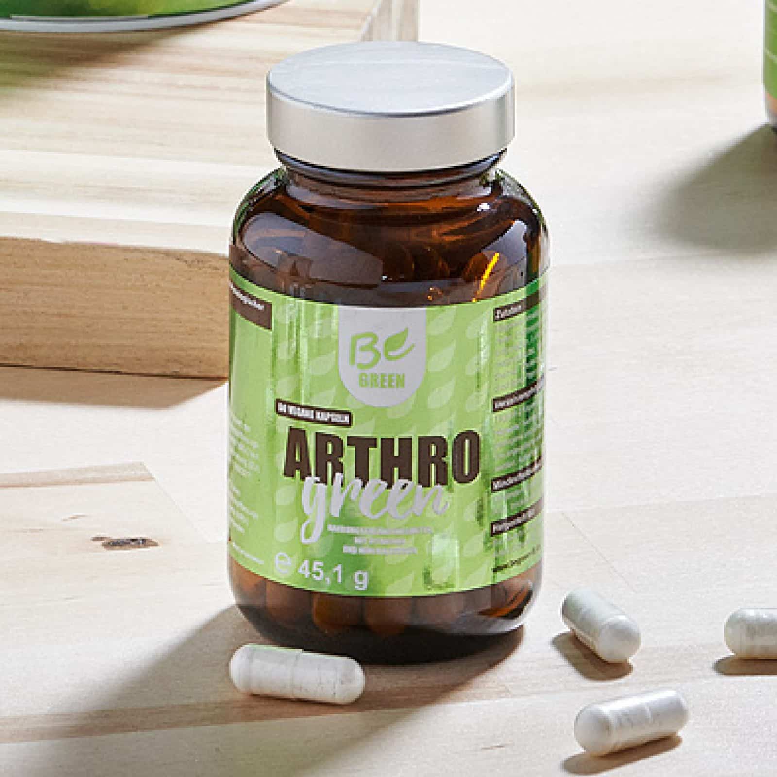 BeGreen Arthro Green Kapseln im Glas mit einzelnen Kapseln auf einem hellen Holztisch