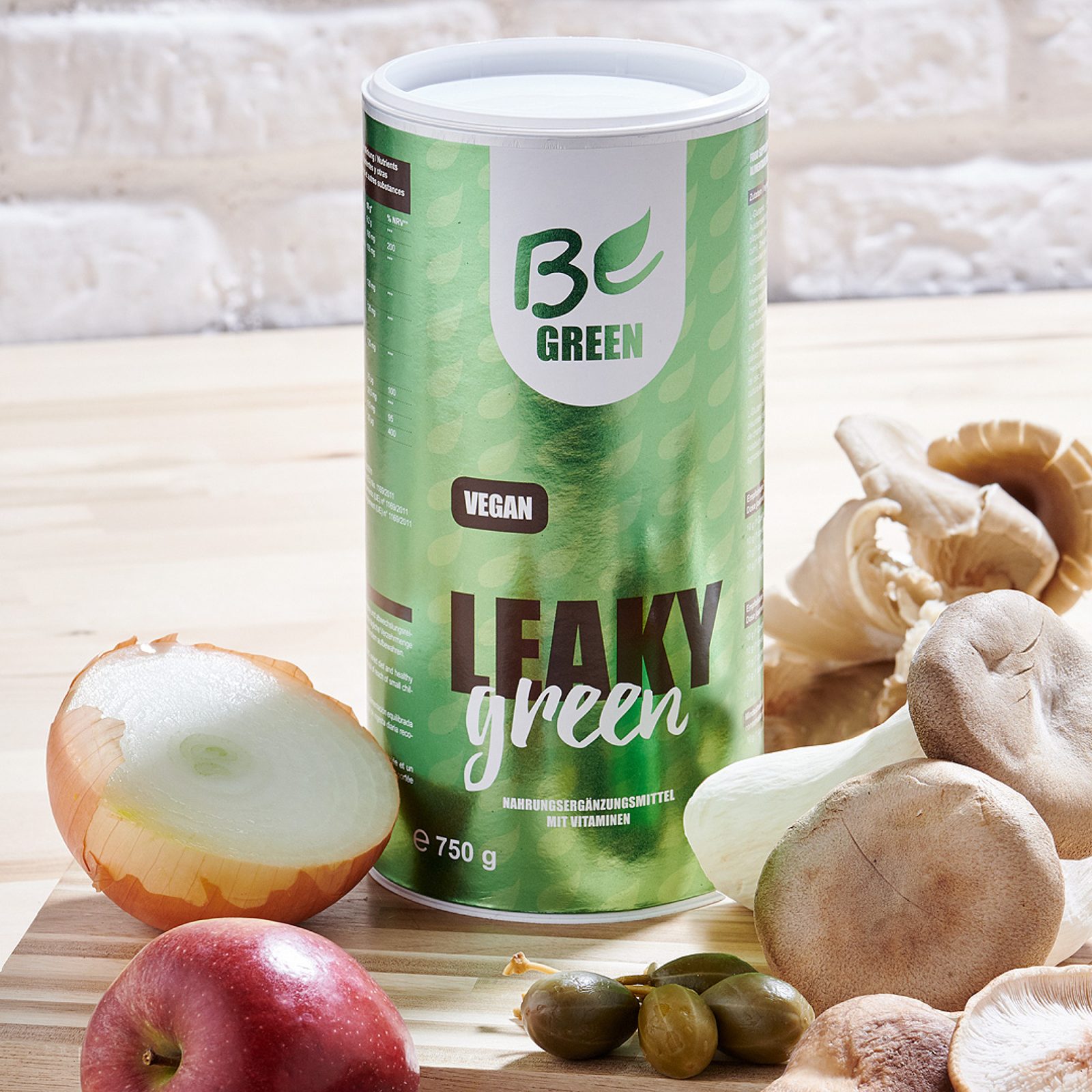 BeGreen Leaky Green Pulver mit frischem Obst und Gemüse auf einem Holztisch